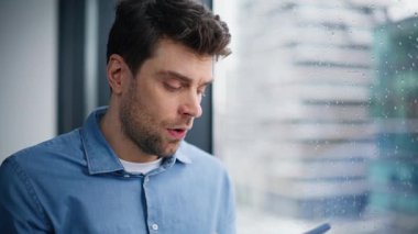 Endişeli çalışan, pencerenin önünde yağmur damlalarıyla konuşurken cep telefonu konuşmasını bitiriyor. Stresli iş adamı, tatminsiz kötü haberi vermek için telefonu kapattı. Ofisteki sorunu düşünen endişeli bir adam.