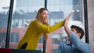 Memnuniyet duyulan patron, ofis iş yerinde birlikte dizüstü bilgisayar ararken yönetici kontrolü yapıyor. Mutlu meslektaşlar beş sevinçli başarılı başlangıç yapıyor. Heyecanlı iş arkadaşları projede işbirliğinin keyfini çıkarıyorlar