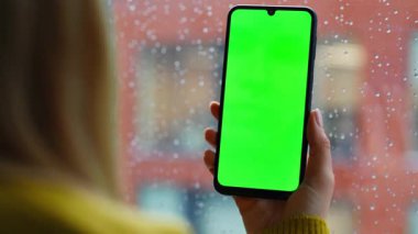 Kız parmakları zumlayan cep telefonu ev penceresinden sosyal medya içeriğini izliyor. Çevrimiçi alışveriş yapan bilinmeyen bir kadın yeşil ekran akıllı telefon kullanıyor. İş kadını iş yerinde krom anahtar telefon kullanıyor.