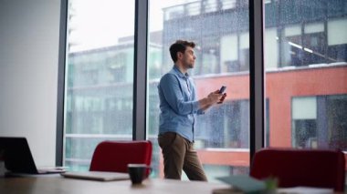 Dairenin panoramik penceresinde cep telefonunu izleyen ciddi bir serbest çalışan. Şehir manzaralı cep telefonu mesajıyla kafası karışmış yakışıklı bir iş adamı. Alınan telefon mesajları üzerine düşünceli yönetici.