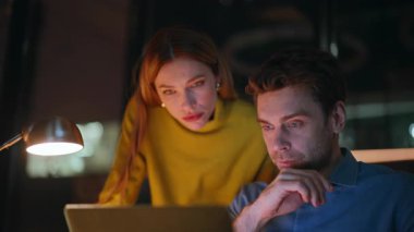 Yakın çalışma arkadaşları, gece ofisindeki dizüstü bilgisayarda harika haberler okuyarak sevinçten havalara uçuyor. Duygusal meslektaşlar başarıya beş tepki veriyor. Aşırı neşeli iş adamları online kazanma konusunda heyecanlı..