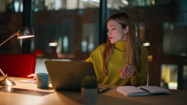 Geç saatlere kadar çalışan, karanlık ofiste lambanın altında defter yazan, yakın plan projeler yapan. Çekici bir kadın laptoptan gece mesaisine gelen verileri not ediyor. Sakin bayan fazla mesai yöneticisi cep telefonunu kontrol ediyor..