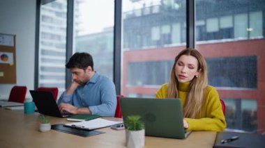 Şirketin açık alanındaki dizüstü bilgisayarlarda çalışan yorgun ofis üyeleri. İki meslektaşım konferans odasının panoramik penceresinin yanında aşırı yükleme yapıyor. Yorgun adam yöneticisi bilgisayarı kapatıyor. Uzaktan kumandayı bitir.