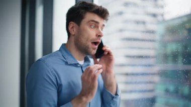 Ofis penceresinin önünde cep telefonuyla bağıran sinirli patron. Cep telefonuyla bağıran kızgın işadamı başarısızlıktan dolayı stresli. Sinirli girişimci akıllı telefon görüşmesiyle tartışır..