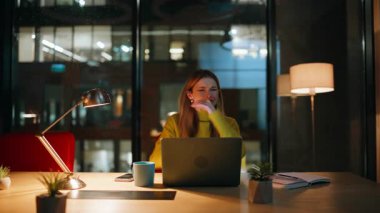 Şok olmuş gece çalışanı dizüstü bilgisayarın kapanmasından endişe ediyor. İş kadınlarının fazla mesai probleminden dolayı stres hissetmesi sinir bozucu. Duygusal kadın, karanlık işyerinde otururken finansal kayıplara tepki veriyor