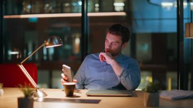 Motivasyonsuz yönetici, akıllı telefondan zamanı kontrol ediyor. Kahve fincanını yakın çekimde karanlık işyerinde oturuyor. Gece ofisinde içki içen ciddi bir iş adamı. Fazla mesaiden sonra dinlenen düşünceli bir çalışan..