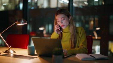 Girişimci akşam geç saatlerde laptopun başında iş yerini arıyor. Akşamları akıllı telefondan konuşan yorgun kadın serbest çalışıyor. Çalışkan iş kadını telefonda fazla mesai yapıyor..