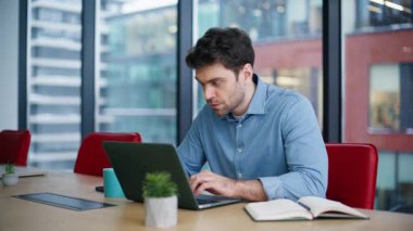 Dizüstü bilgisayarda internette sörf yapan odaklı yönetici ofis alanı yakın plan. Ciddi bir iş adamı internetten kahve fincanı alıyor. İş yerindeki şirket kariyerini düşünen yakışıklı bir çalışan..