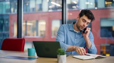 İşletme danışmanı, akıllı telefondan konuşuyor. Bilgisayarlı iş yeri, yakın plan. Meşgul işadamı ofisteki bilgisayarda çalışan ortakları arıyor. Cep telefonuyla proje tartışması yapan yakışıklı girişimci.