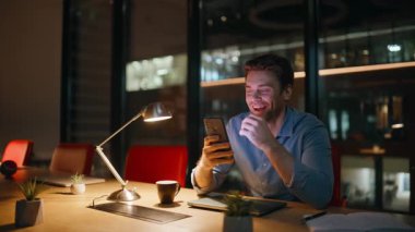 Gece müdürü mesai sonrası cep telefonuna mesaj atıyor. Gülümseyen iş adamı, gizli ofiste oturmuş akıllı telefon mesajı atıyor. Çalışma alanındaki cep telefonundan sosyal medyada gezinen mutlu serbest yazar.