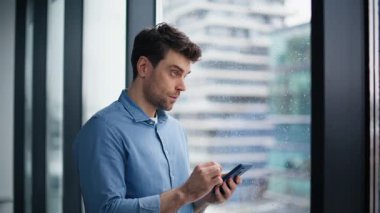 Ofis penceresinde akıllı telefon uygulamasına göz atan düşünceli girişimci. Ciddi bir işadamı cep telefonu tebligatını bekleme salonunda okuyor. İçerideki cep telefonunu kullanarak kendine güvenen yönetici e- posta gönderiyor