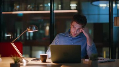 Uzaktan kumandalı işçi gece iş yerinde dizüstü bilgisayara göz atıyor ve kendini tükenmiş hissediyor. Yorgun iş adamı karanlık ofis alanındaki bilgisayar ekranına bakıyor. Çok çalışan şirket yöneticisi fazla mesai yapmaya istekli değil..