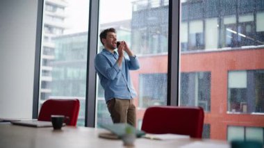 Ofis panoramik penceresinin yanında konuşan bir iş danışmanı. Kendine güvenen iş adamı akıllı telefon görüşmesiyle fikirleri tartışıyor. Gülümseyen müdür içeride dostça cep telefonu konuşmalarını sever..