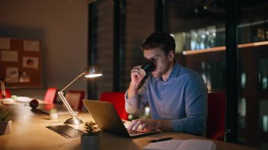 Fazla mesai yöneticisi karanlık ofiste kahve içip dizüstü bilgisayar izliyor. Yorgun işadamı gece işyerinde kafein içeceği yudumluyor. Depresyondaki adam gece lambanın altında bilgisayar başında çalışıyor..