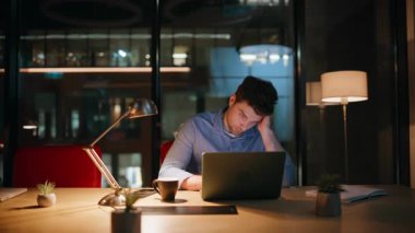 Gece çalışma alanında çok çalışan bir yönetici dizüstü bilgisayara göz atıyor. Yorgun işadamı bilgisayarını kapatıyor. Lamba ışığı altında fazla mesai yapmaya istekli değil. Üzgün adam, serbest çalışan, karanlık ofiste kendini tükenmiş hissediyor..