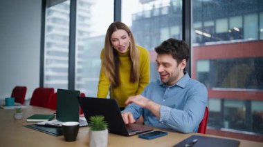 Stajyer asistanı destekleyen ofis yöneticisi ortak çalışma alanında dizüstü bilgisayar arıyor. Dost canlısı kadın danışman iş yerindeki erkek yöneticiye projeyi açıklıyor. Şirket meslektaşları birlikte iş birliği yapıyorlar..