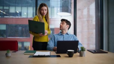Dost canlısı akıl hocası ofisteki müdürün dizüstü bilgisayarını gösteriyor. Gülümseyen kadın, iş yerinde oturan bir adamla konuşuyor. Pozitif iş arkadaşları açık alanda iş stratejisini tartışıyor.