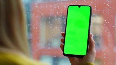 Kadın parmağı kroma tuşlu cep telefonuna dokunuyor çevrimiçi içeriği tarıyor. Tanımlanamayan bir kadın uzaktan yeşil ekran akıllı telefon uygulamasından alışveriş yapıyor. İş kadını model telefondan iş mesajını okuyor