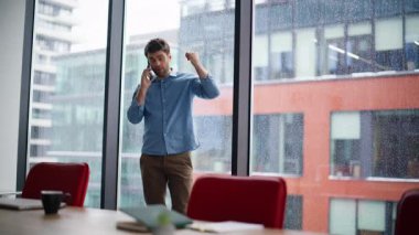 Müdür gergin bir şekilde toplantı odasında bekliyor. Stresli iş adamı, şehir manzaralı, cam kenarındaki cep telefonu konuşmasından endişeli. Sorunlu girişimci akıllı telefon iletişiminden memnun değil.