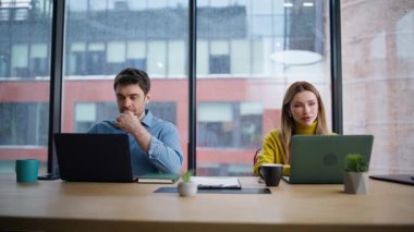 Şirketin ortak çalışma alanında dizüstü bilgisayarda çalışan iki iş arkadaşı. Modern iç mekanda panoramik pencereli bilgisayar geliştiren birkaç iş arkadaşı. İki yönetici takım çalışması..