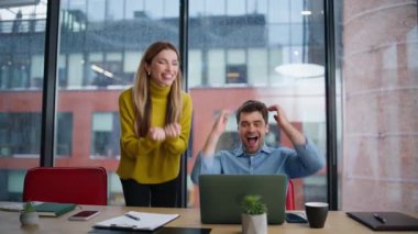 Aşırı keyifli ortaklar ofis panoramik penceresinden beş tane e-posta yolluyor. Başarılı bir başlangıca duygusal meslektaşlar tepki veriyor. İki mutlu iş arkadaşı birlikte iş başarısını kutluyor.