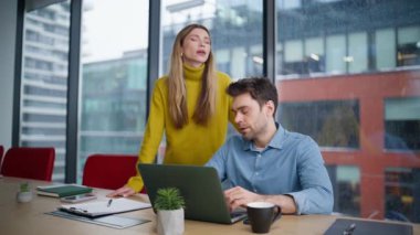 Hayal kırıklığına uğramış ofis ekibi panoramik pencerede dizüstü bilgisayar bildirimi okuyor. Profesyonel erkek kadın iş başarısızlığı yüzünden hayal kırıklığına uğradı. Stresli meslektaşlar mali kayıplara umutsuzlukla tepki veriyorlar. 