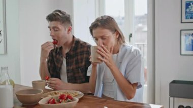 Kaygısız kız arkadaş erkek arkadaşıyla yemek yiyor. Kapanışta gülümseyen çift konuşuyor. Parlak mutfakta huzurlu bir sabahın tadını çıkarıyorlar. Pozitif eşlerin evde kahve içmesi. Boş zaman rutini.
