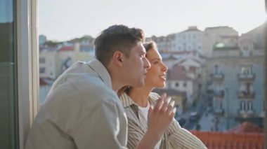 Geceleri balkonda iletişim kuran gülümseyen bir çift. Romantik insanlar güzel şehir manzarasına hayran kalarak birlikte seyahat ederler. Mutlu eşler ev terasında kentsel mimariyi tartışıyor..