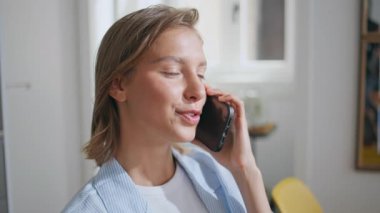 Genç bir kadın kapalı alanda akıllı telefonla iletişim kuruyor. Gülümseyen kadın portresi sabah güneşinde gündelik sohbetin keyfini çıkarıyor. Pijamalı rahat kısa saçlı kız evde dinleniyor cep telefonuyla dedikodu yapıyor..