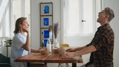 Aile çifti hafta sonları birlikte kahvaltı yapıyor. Neşeli eşler modern mutfakta yemekle oynuyorlar. Çilek yakalayan oyuncu sevgili kız arkadaşına beşlik çakıyor. Pozitif bağlanma