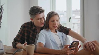 Rahatlamış aile alışverişi sabah internetten. Sevgi dolu bir adam güzel kız arkadaşını öpüyor ve evde sosyal medya içeriğini tartışıyor. Gülümseyen gençler cep telefonu kullanıyor. Sevgi dolu mutlu bir ilişki..