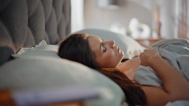 Yatakta uyanan bir kadın cep telefonunun kapanma zamanını kontrol ediyor. Genç esmer, başını sıcak bir battaniyeyle örterek uykusuz bir sabah geçiriyor. Tatminsiz bayan güne başlamak için motivasyonsuz akıllı telefon gibi görünüyor..