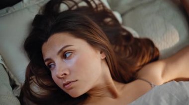 Akıllı telefonları kontrol eden bir kadın sabahın erken saatlerinde ev kapanışında mesaj alıyor. Uykusuz esmer, cep telefonu alarmıyla uyandı. Ayağa kalkmak için motivasyonu yoktu. Uykulu kadın yumuşak battaniyeyle yüzünü örtüyor.