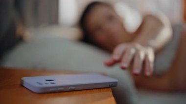 Uykucu kız akıllı telefona uzanıyor. Ev yatağında rahat bir şekilde uzanıyor. Güzel bir kadın cep telefonundan romantik bir mesaj alıyor. Gülümseyen kadın cep telefonu mesajlarına cevap vererek uyanıyor..