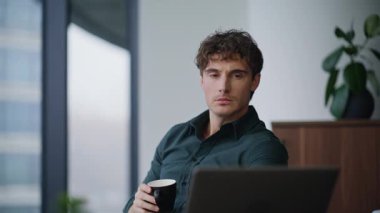 Düşünceli CEO, modern ofis panoramik penceresinde kahve yudumlarken iş dünyasının fikirlerini düşünüyor. Düşünceli iş adamı strateji içeceği üzerine kafa yoruyor. Şık patron iş yerinde iş molası veriyor..