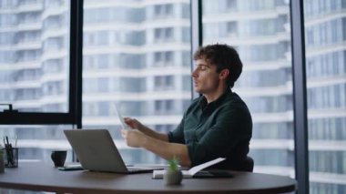 Modern ofis içi pazarlıklarda konuşan bir iş adamı. İş yerindeki video görüşmesiyle gülümseyen profesyonel tartışma projesi. Sanal toplantıda dizüstü bilgisayarlı web kamerasıyla konuşan adam yöneticisi.