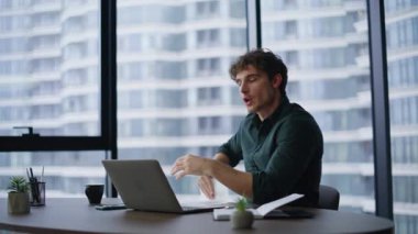 Modern ofisteki laptop web kamerasına finansal belgeleri gösteren öfkeli yatırımcı videosu. Öfkeli iş adamı duygusal olarak bilgisayar kapatma konferansını bitirdi. Gergin adam, fırlatma raporunu yırtıyor.