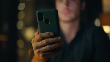 Akşamları iş yerinde akıllı telefonları tutan serbest çalışan eller. Gülümseyen işadamı karanlık ofiste cep telefonuyla sohbet etmekten hoşlanıyor. Mutlu yönetici gece geç saatlerde cep telefonuna mesaj atıyor.