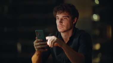 Neşeli, serbest çalışan, gece iş yerinde cep telefonuna göz atan biri. Gülümseyen yönetici cep telefonundan iş teklifini okuyordu. Akıllı telefondan online alışveriş yapan mutlu iş adamı.