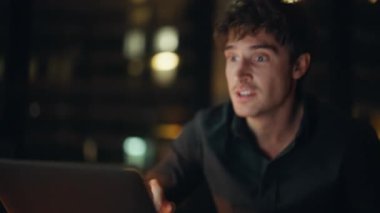 Karanlık iş yerinde bilgisayar ekranı görüntüsü almasına şaşırdım. Duygusal iş adamı, evet jesti göstererek iş başarısını kutluyor. Heyecanlı başlangıç projesi başarısını akşam kutluyor..