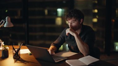 Depresyondaki işçi, gece şirketinin iş yerinde dizüstü bilgisayara bakıyor. Yorgun iş adamı gece geç saatlerde bilgisayar başında çalışırken boynu ağrır. Yorgun, serbest çalışan, gözlerini ovuşturan, karanlık bir yerde aleti kapatan..