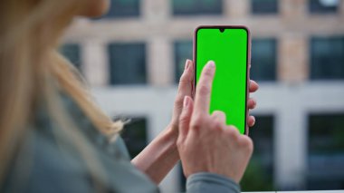 Dışarıdaki telefon ekranını elle dinleyen bir kadın. Bilinmeyen gevşek bir bayan Chromakey akıllı telefonuna dokunuyor iş e-postalarını kontrol ediyor. Kimliği belirsiz sarışın iş kadını yeşil ekran cep telefonunu tek başına tutuyor.