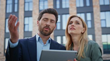 İş ortakları, mimar mekanında tablet planlama şirketinin büyümesini tartışıyor. Stratejiyi analiz eden güvenilir meslektaşlar modern ofis inşaatında sekmeyle birlikte konuşuyorlar.