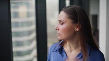 Endişeli bayan yönetici akıllı telefona bakıyor ve işten çıkarma uyarısı alıyor. Ofis penceresinin önünde cep telefonu tutan sinirli iş kadını. Şaşkın şirket çalışanı iş yerinde stres hissediyor.