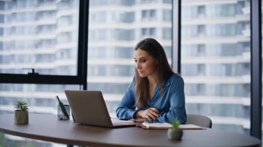İnternetteki toplantıda konuşan iş adayı modern işyerinde oturuyor. Gülümseyen bayan yöneticinin dizüstü bilgisayara veda etmesi webcam bitiş videosu. Başarılı iş kadını içeride sanal müzakere yürütüyor.