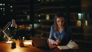 Modern kurumsal ofiste yönetici planlama projesi. Çalışkan bir iş kadını dizüstü bilgisayar aramaktan yoruldu. Gece işyerinde çalışan serbest çalışan bir kadın..