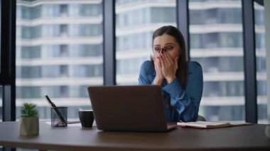 İşletme müdürü şirketin ofisindeki dizüstü bilgisayara bakan haberleri hayrete düşürdü. Şaşkın iş kadını işyerinde mali geliri sevinçle karşılıyor. Mutlu kadın yönetici duygusal olarak iş tanıtımına tepki veriyor..