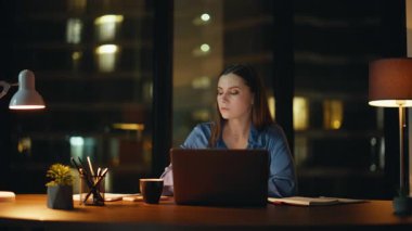 Aşırı yüklü bir kadın karanlık şirket işyerinde geç saate kadar çalışıyor. Yorgun iş kadını bilgisayarını kapatırken fazla mesai yapmak istemiyor. Yorgun bayan, mesaiyi bitirin, gece ofisinde oturun..