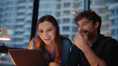 İş arkadaşları sanal toplantıda konuşuyor. Karanlık ofisteki web kameralarına bakıyorlar. Gülümseyen meslektaşlar akşam işyerinden arıyorlar. İki ortak internet sohbetinde dostça sohbetin keyfini çıkarıyor.