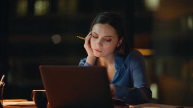 Üzücü çalışan dizüstü bilgisayar işyerinde gece geç saatlerde fazla mesai yapmaktan yoruldu. İş kadını, gece ofisindeki bilgisayarda çalışmaya hevesli değil. Çok çalışan kadın işkolik, evde kendini tükenmiş hissediyor.